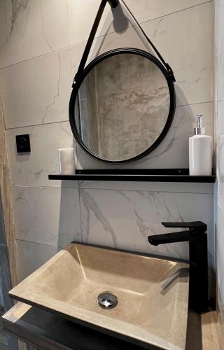 a bathroom sink with a round mirror above it at CASA CALVI in Calvi