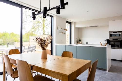 uma cozinha e sala de jantar com uma mesa de madeira e cadeiras em Het Preshoekhuis em Lauwe