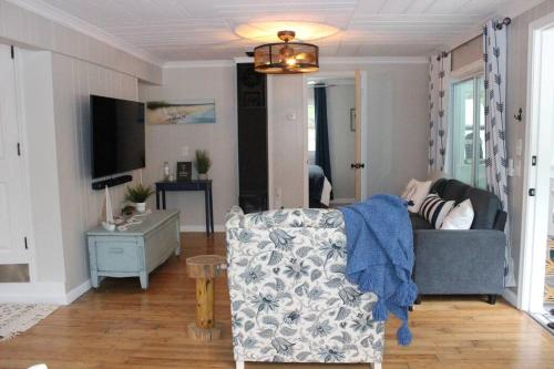 a living room with a couch and a tv at Cozy cottage just minutes from Lake Michigan! in Pentwater