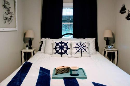 1 dormitorio con 1 cama con almohadas blancas y negras en Cozy cottage just minutes from Lake Michigan! en Pentwater