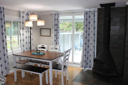 a dining room with a table and a fireplace at Cozy cottage just minutes from Lake Michigan! in Pentwater