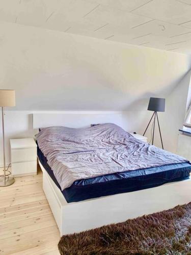 a bedroom with a bed in a white room at Big villa in stege near møns klint with trampolin in Stege