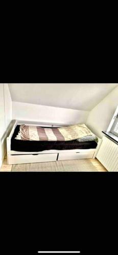 a small bed in a corner of a room at Big villa in stege near møns klint with trampolin in Stege