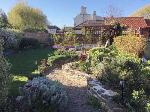 a garden with a stone path and a gazebo at The Old Posthouse B&B in Caenby
