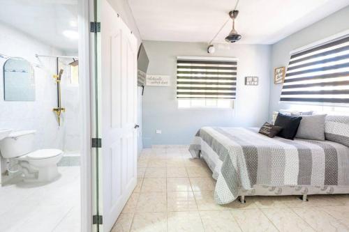 a bedroom with a bed and a sink and a toilet at Hermosa Suites #3 in the heart of PUNTA CANA in Punta Cana