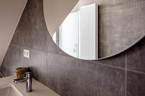 La salle de bains est pourvue d'un lavabo et d'un miroir. dans l'établissement Het Preshoekhuis, à Lauwe