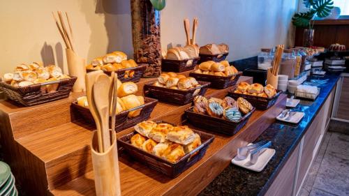 a buffet with several baskets of bread and pastries at HY Apartments & Hotels in Recife