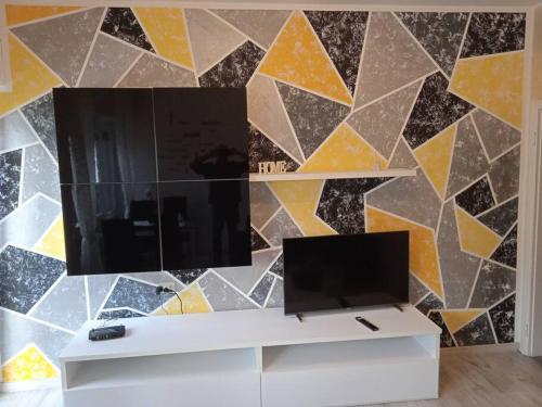 a living room with a tv and a mosaic wall at Casa Orchidea in Oria