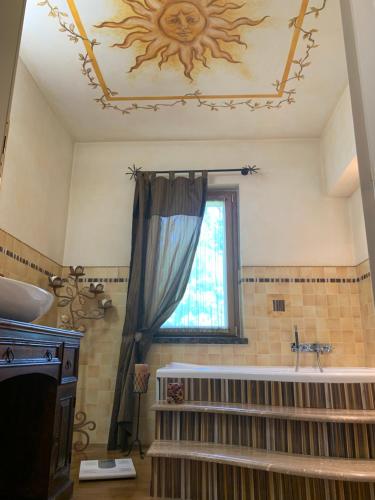 uma casa de banho com uma banheira, um lavatório e uma janela em Katherine House em Aulla