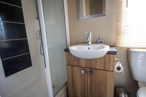a small bathroom with a sink and a toilet at 4 Berth Caravan With Decking And Wifi At Carlton Meres In Suffolk Ref 60010k in Saxmundham