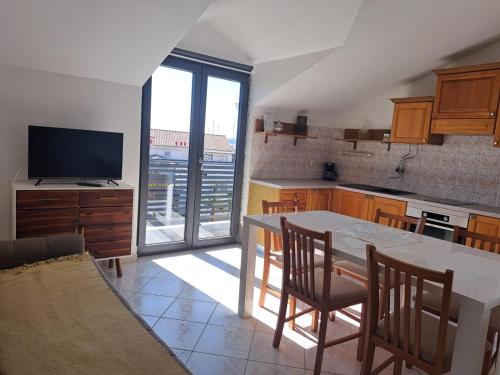 a kitchen with a table and chairs and a television at Apartments Centar in Vodice