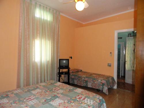 a hotel room with two beds and a television at Chiaia Apartments by Caseaponza it in Ponza