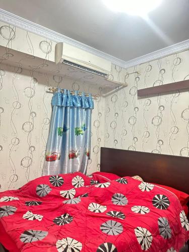 a bedroom with a red bed with a red and white blanket at Apartemen Casablanca 2Br in Jakarta