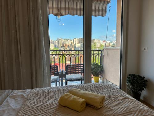 a bedroom with a bed with a view of a balcony at YellowHouse in Prishtinë