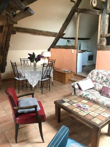 een woonkamer met een tafel en een bank bij Ancien moulin du 18 ieme in Assé-le-Riboul