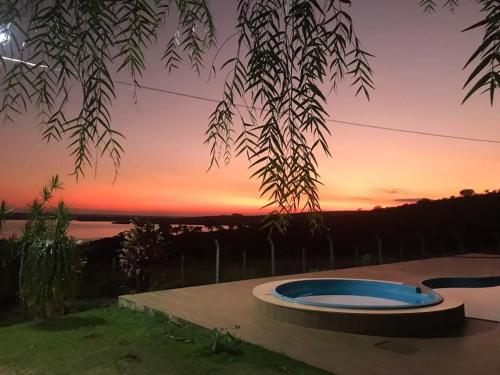 a view of a sunset from a house with a swimming pool at Fazenda Dona Netinha Corumbá IV MDPF in Luziânia