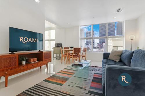 een woonkamer met een blauwe bank en een tv bij Roami at The Ralston in Miami