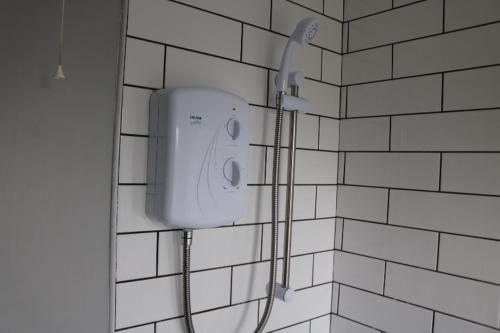 a shower in a bathroom with a white tiled wall at Charming 2 Bed House - Family Friendly in Nottingham