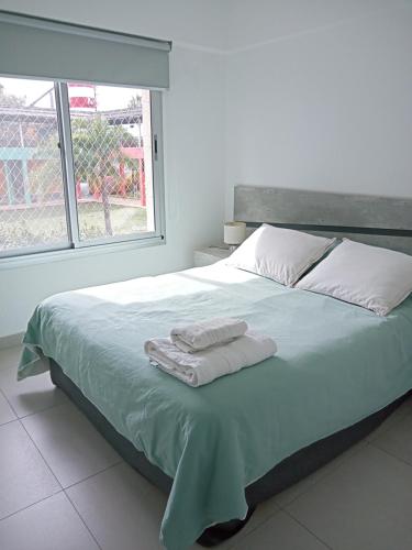 sypialnia z dużym łóżkiem z dwoma ręcznikami w obiekcie Vivanco w mieście Tigre
