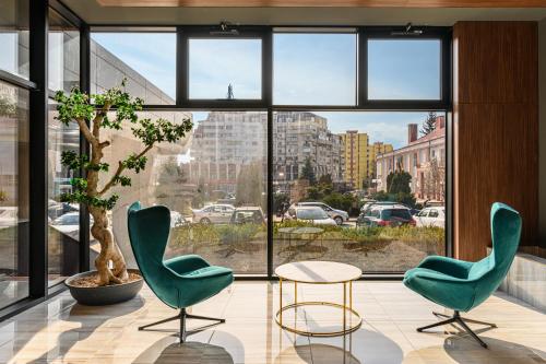 2 sillas y una mesa en una habitación con ventana grande en HOTEL CENTRAL, en Paşcani
