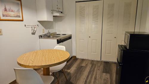 a small kitchen with a wooden table and a sink at The Cedars Inn Hotel & Convention Centre in Gibsons