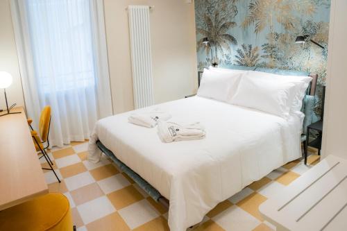 a bedroom with a white bed with towels on it at Palazzo Scappi Gardi Luxury Apartments in Bologna