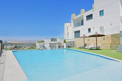 a large swimming pool in front of a building at Sukha Apartments by NRAS in Gran Alacant