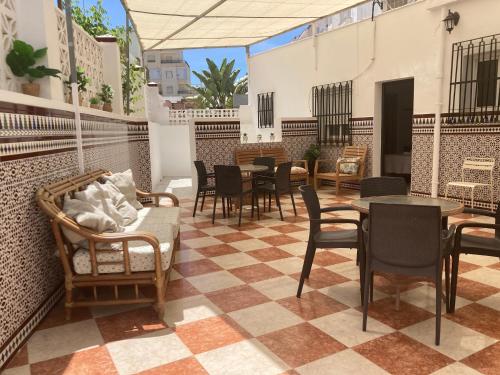 a patio with chairs tables and tables in a restaurant at Hostal Avenida by Bossh! Hotels in Chipiona
