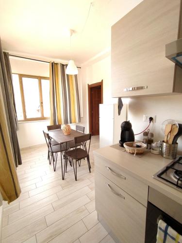 a kitchen and dining room with a table and chairs at Miky's House in Teulada