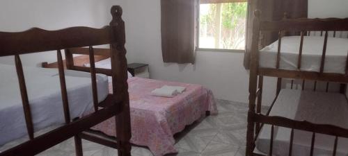 a bedroom with two bunk beds and a window at Pousada Recanto Dos Tucanos in Capitólio