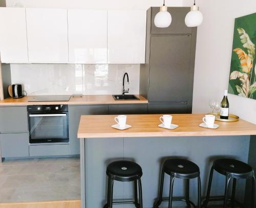 a kitchen with a counter with stools and a counter top at APARTAMENT OGRODY in Leszno