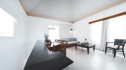 a kitchen and living room with a table and chairs at Zeus Village Resort - Adults Only in Kato Daratso