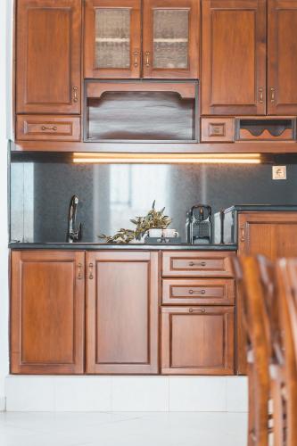 a kitchen with wooden cabinets and a sink at Zeus Village Resort - Adults Only in Kato Daratso