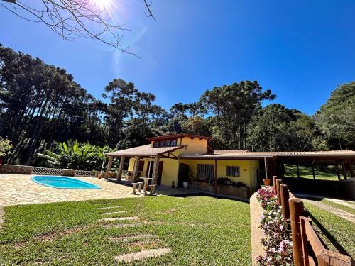 una casa con una valla y un patio en Casa de Campo Vizinha da Lua, en Monte Verde