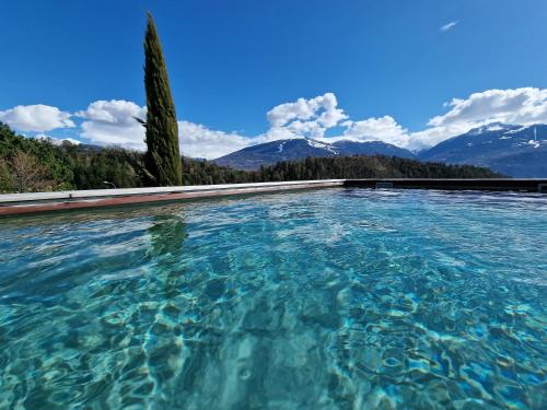 a pool of water with mountains in the background at Bella Flocon appartements min 2 Nights Special weekly and monthly prices in Savièse
