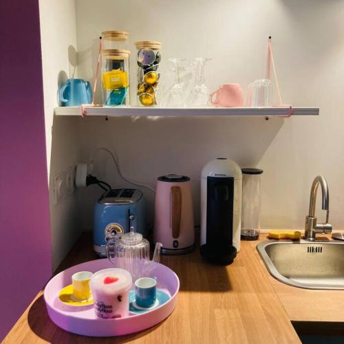 um balcão de cozinha com uma bandeja com copos em Barbapappart - Un studio coloré dans le centre de Rouen em Rouen