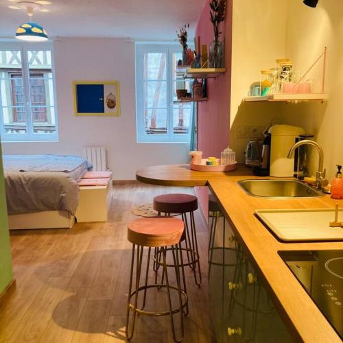 une cuisine avec deux tabourets de bar et une cuisine avec un lit dans l'établissement Barbapappart - Un studio coloré dans le centre de Rouen, à Rouen