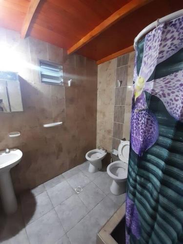 a bathroom with two toilets and a sink and a shower at Casa amplia y cómoda in General Alvear