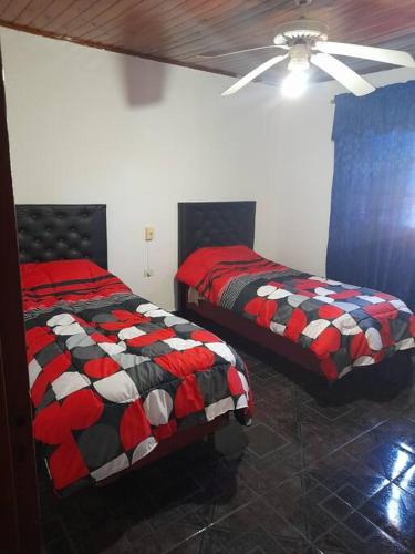 Casa amplia y cómoda في خنيرال آلفيار: غرفة نوم بسريرين ومروحة سقف