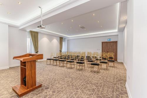 a conference room with a row of chairs and a podium at HOTEL CENTRAL Pascani in Paşcani