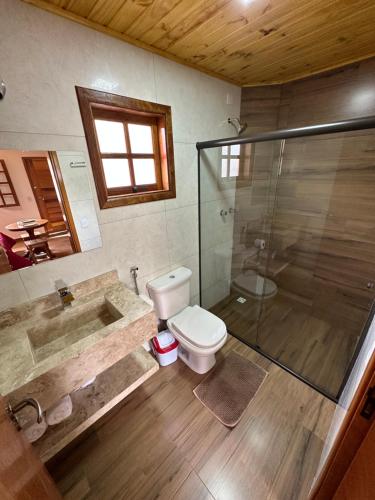 a bathroom with a tub and a toilet and a shower at Pousada Requinte da Serra in Monte Verde