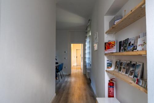 Un pasillo de una casa con paredes blancas y estantes de madera. en SulGarda Holiday Apartment, en Arco