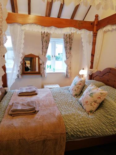 a bedroom with a large bed and a window at Poplar Cottage in Woodhall Spa