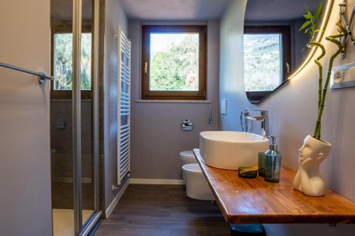 La salle de bains est pourvue d'une baignoire, d'un lavabo et de toilettes. dans l'établissement SulGarda Holiday Apartment, à Arco