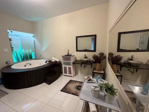 a large bathroom with a tub and a sink at Deck Hospedaria in Cunha