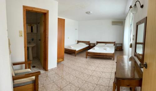 a room with two beds and a bathroom at Sfinias Apartments in Kali Limenes