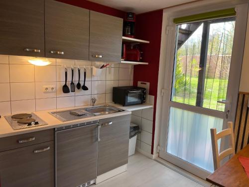 a small kitchen with a sink and a window at Fewo EG im roten Haus am Ostsee Radweg OVS 103 neu 20 in Blowatz