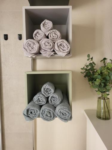 a pile of towels on a shelf in a bathroom at Old Town Sedlar Apartment in Split
