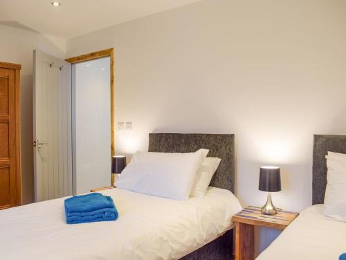 a bedroom with two beds and a blue towel on the bed at Lletyr Saer in Pen-y-bont-fawr