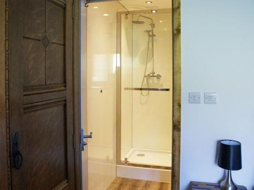 uma casa de banho com um chuveiro e uma porta de vidro em Lletyr Saer em Pen-y-bont-fawr
